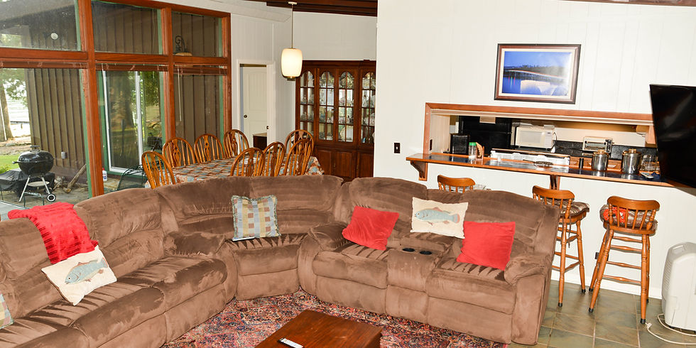 Open living area with sectional sofa, dining table, and breakfast bar at this lakefront retreat on Lake Guntersville