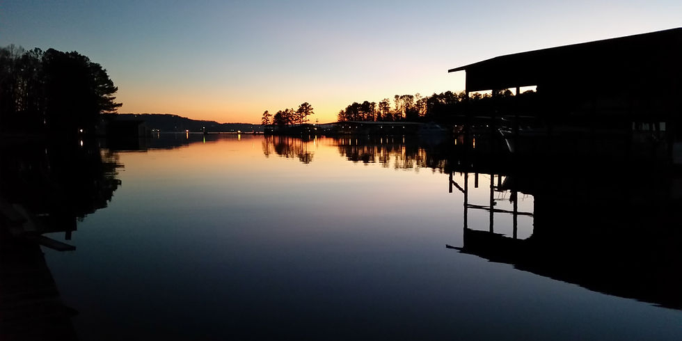Sunset over the calm cove on Lake Guntersville viewed from the Guntersville Getaway boathouse and dock